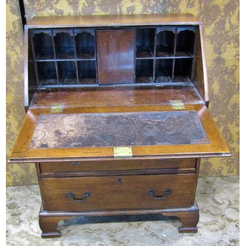 2354 - An Edwardian oak bureau of two long and two short drawers, the fall flap enclosing a fitted interior... 