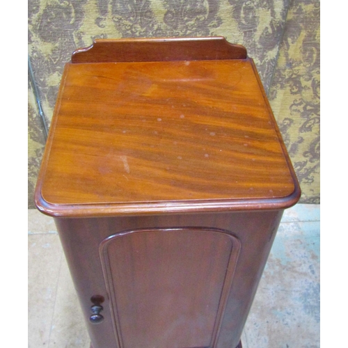 2167 - A Victorian mahogany bedside cupboard enclosed by a moulded arched panelled door