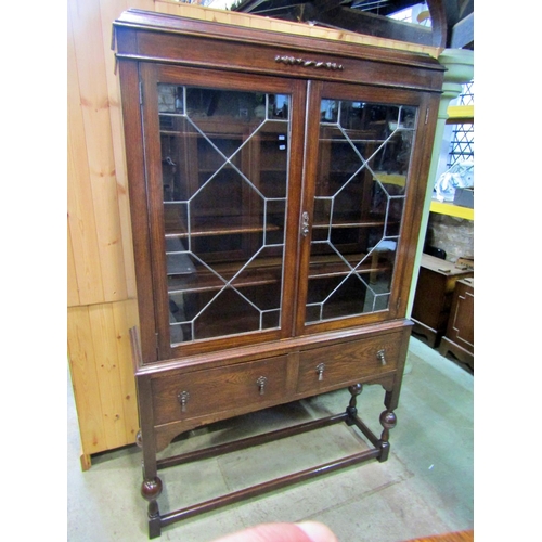 2206 - An Edwardian oak display cabinet with leaded astragal glazed panelled doors over two frieze drawers ... 