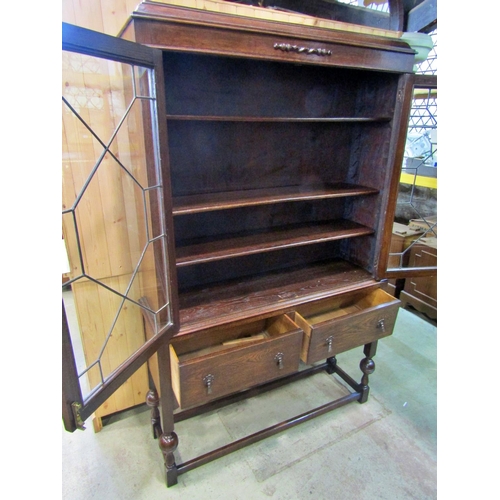 2206 - An Edwardian oak display cabinet with leaded astragal glazed panelled doors over two frieze drawers ... 