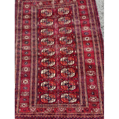 2709 - A Turkoman carpet with two rows of small elephant gul on a predominantly red ground (split and repai... 