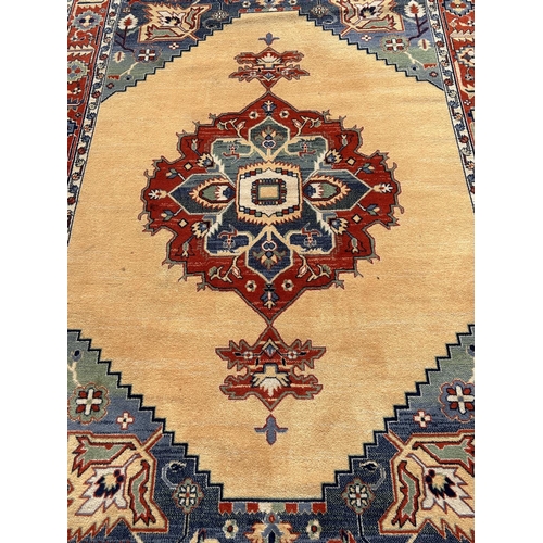 2713 - A Modern machine made rug of middle eastern design with central medallion in bright colours, 290cm x... 