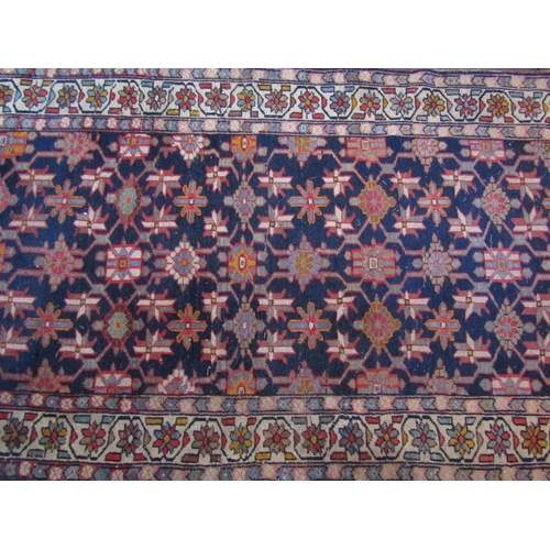 2723 - An old eastern carpet, the central field in ink blue with multi repeating abstract floral detail, wi... 