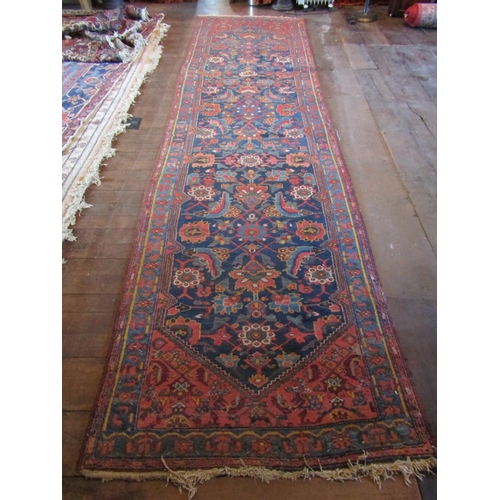 2729 - An old eastern wool runner, the central dark blue ground supporting abstract floral detail, within f... 