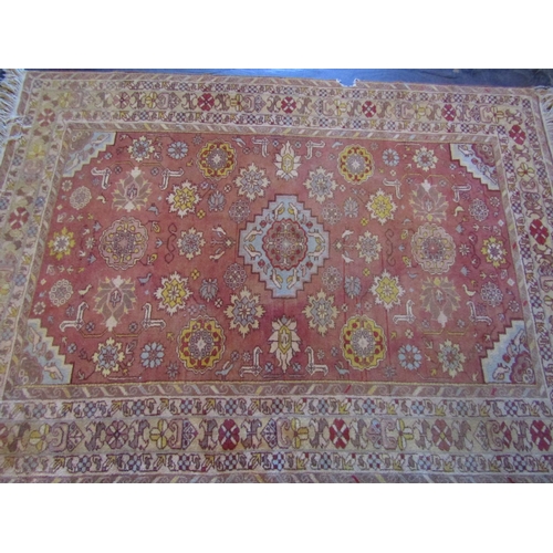 2719 - An eastern wool rug with red ground field central medallion and floral detail, within alternating re... 