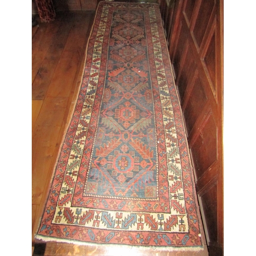 2721 - An old eastern wool runner with six medallion centre upon an ink coloured ground, within triple alte... 