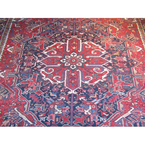 2732 - An eastern wool carpet, the central lozenge in red upon a blue and red ground field with busy abstra... 