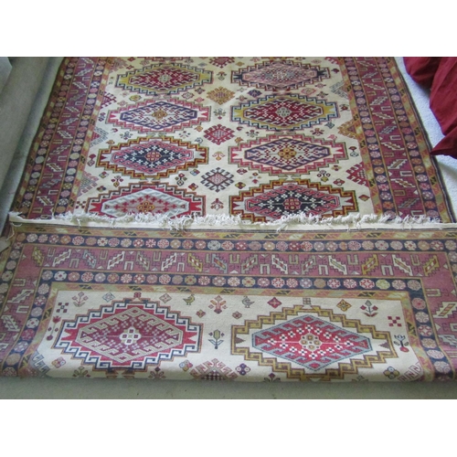 2727 - An eastern wool rug with beige field, with sixteen lozenge shaped medallions, further geometric deta... 