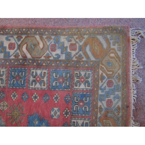 2720 - An eastern wool rug, with triple medallion centre upon a pink field, set within running geometric bo... 