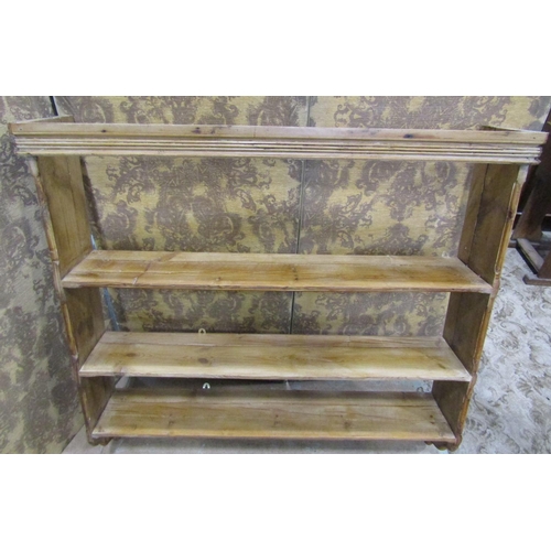 2174 - A stripped pine country made wall rack with three fixed shelves flanked by chamfered and moulded det... 