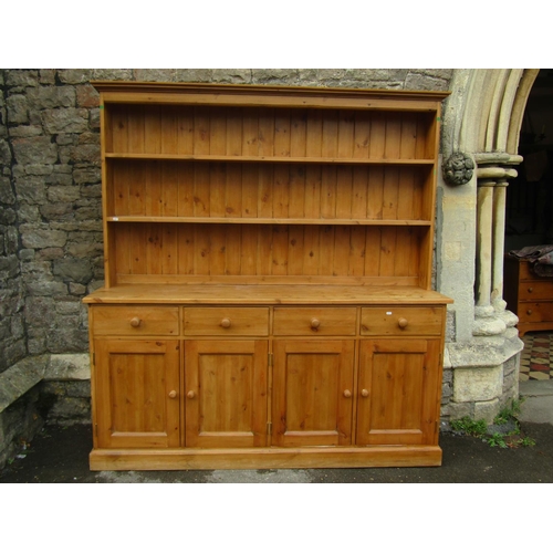 2212 - A waxed pine kitchen dresser, the lower section enclosed by four panelled doors and four frieze draw... 