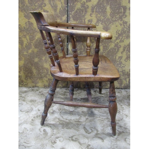 2320 - A 19th century elm captain's chair of usual form with turned spindles