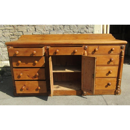 2431 - A Victorian pine kitchen dresser, central arched and panelled doors flanked by an arrangement of nin... 