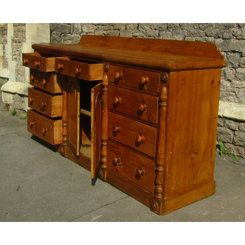 2431 - A Victorian pine kitchen dresser, central arched and panelled doors flanked by an arrangement of nin... 