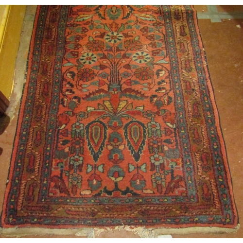 2725 - A very long eastern style runner, with repeating floral and vase detail, upon a pink ground within n... 