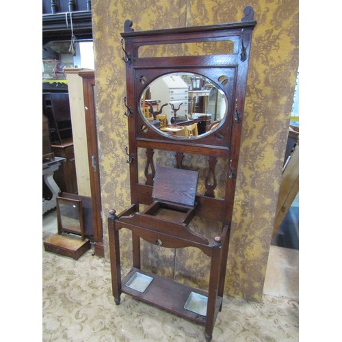 2351A - An early 20th century Arts & Crafts style oak hallstand with pierced detail and enclosing an oval be... 