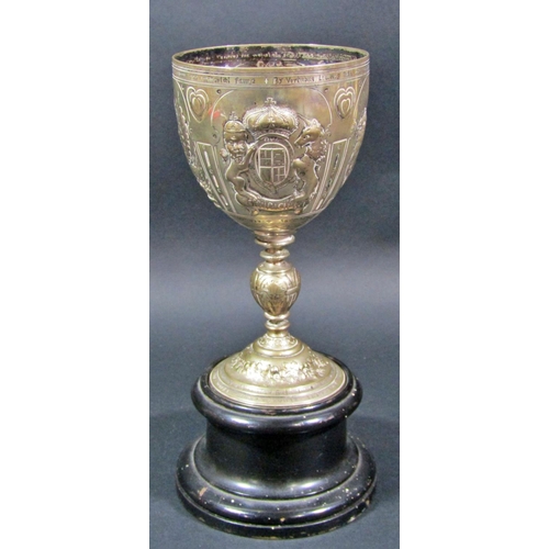 A silver metal chalice engraved with several English quotations and heraldic beasts, raised on a wooden stand, 21.5cm high, 12.8oz approx