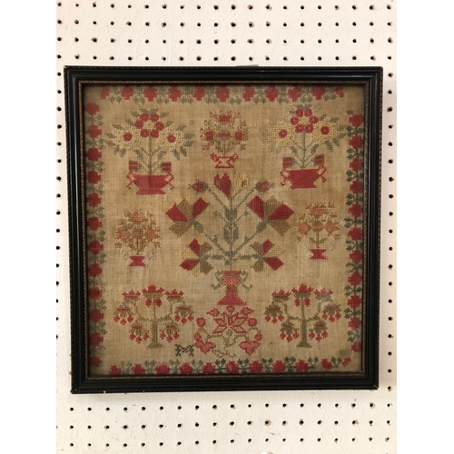 73 - 19th century needlework sampler, unsigned, decorated with a central urn of flowers surrounded by sev... 