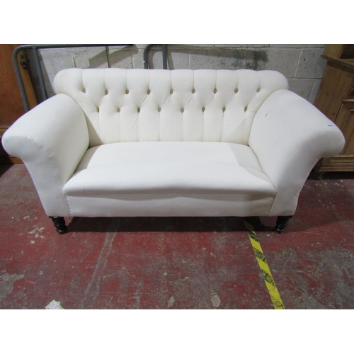 2447 - A late Victorian button back sofa with scrolled arms on turned supports, freshly upholstered in cali... 