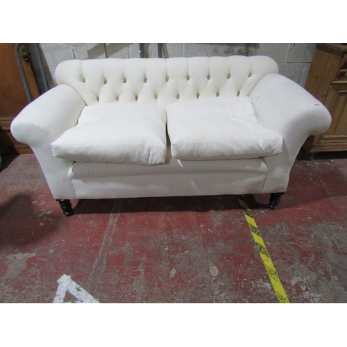 2447 - A late Victorian button back sofa with scrolled arms on turned supports, freshly upholstered in cali... 