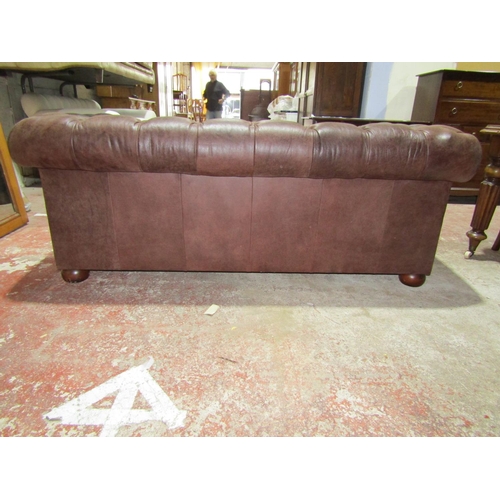 2448 - A Victorian style chesterfield in a mid brown leather, with buttoned back and scrolled arms, 190cm w... 