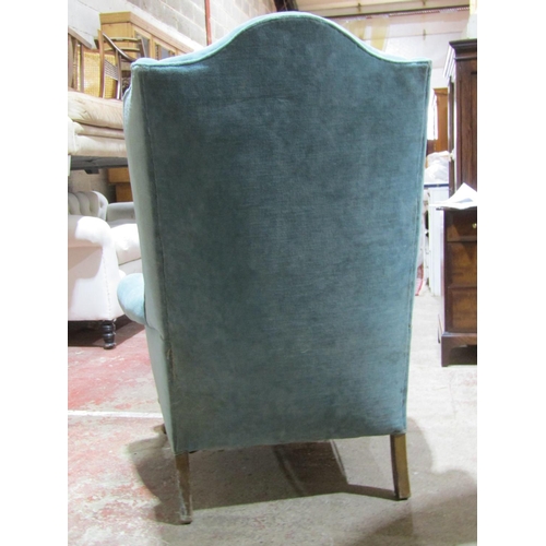 2452 - A Georgian style wing chair with scrolled arms on short cabriole supports