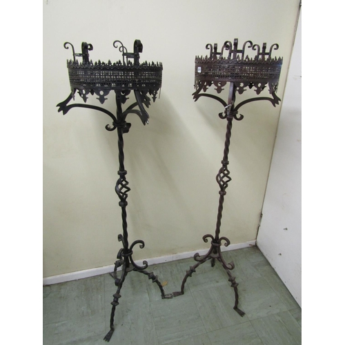 2477 - A pair of good quality had wrought iron candle stands in a Gothic manner, each supporting three cand... 