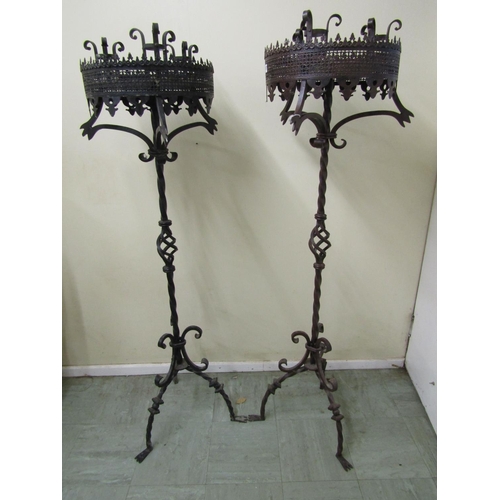 2477 - A pair of good quality had wrought iron candle stands in a Gothic manner, each supporting three cand... 