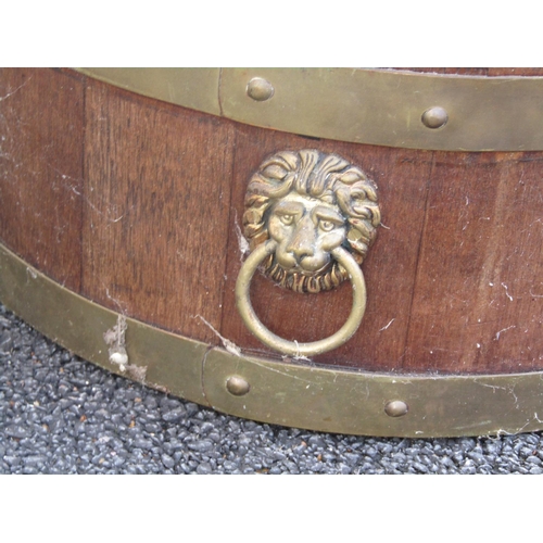 2496 - A Lister & Co teakwood jardinière/wine cooler of oval form, brass banded with lion mask ring named G... 