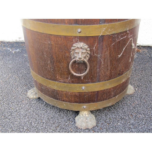 2498 - A Lister oak jardiniere brass banded with lions mask and ring handles and lions paw feet