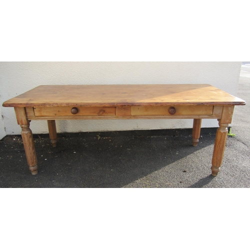 2515 - A stripped pine farmhouse kitchen table, the plank top with two frieze drawers on hexagonal supports... 