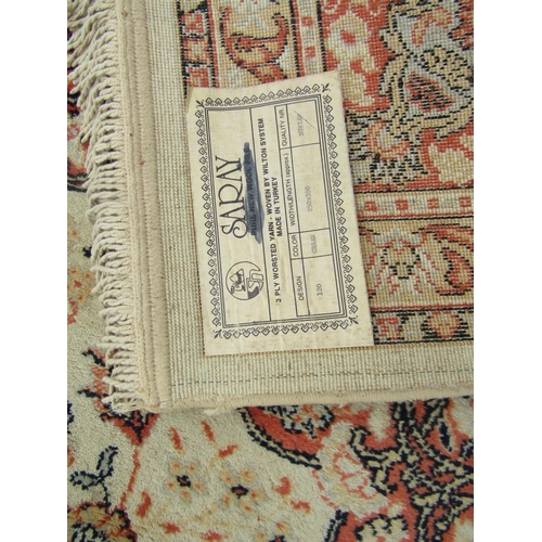 2737 - A Turkish Wilton type machine made rug with traditional Perisan design in tones of cream and orange,... 