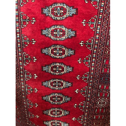 2738 - A Princess Bokhara design rug with eleven central lozenges on a crimson ground, 95 x 180 cm