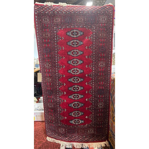 2738 - A Princess Bokhara design rug with eleven central lozenges on a crimson ground, 95 x 180 cm