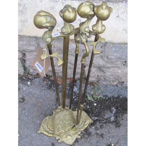 2092 - A cast brass fireside companion set with claw and ball pommels and scrolling tray base, (af)