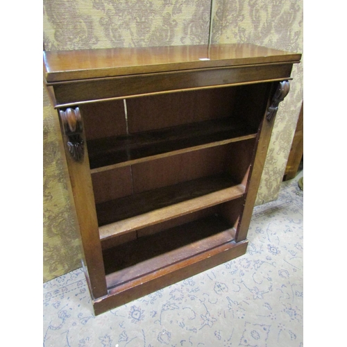 2111 - A Victorian mahogany veneered floorstanding open bookcase with two adjustable shelves flanked by car... 