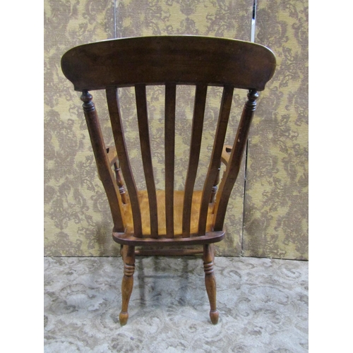 2171 - An antique Windsor stained elm and beechwood lathe back elbow chair with saddle shaped seat