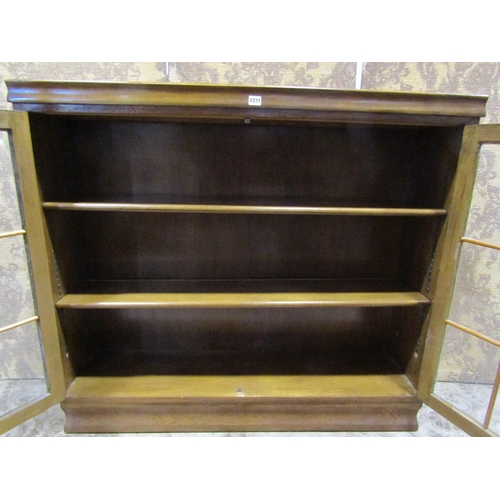 2231 - An oak bookcase enclosed by a pair of astragal glazed panelled doors 122 cm wide