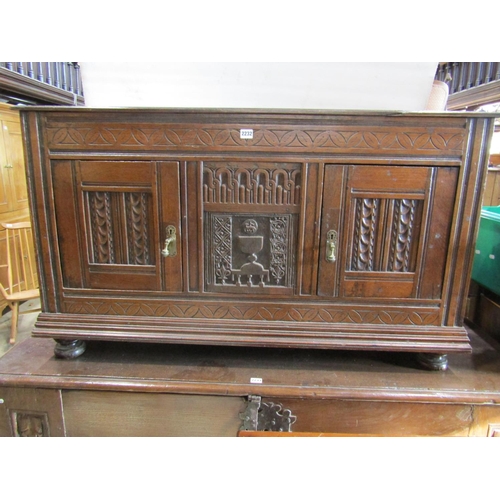 2232 - Antique oak side cupboard enclosed by two doors with additional carved panel work including lamb and... 