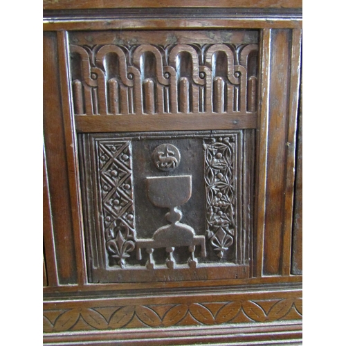 2232 - Antique oak side cupboard enclosed by two doors with additional carved panel work including lamb and... 