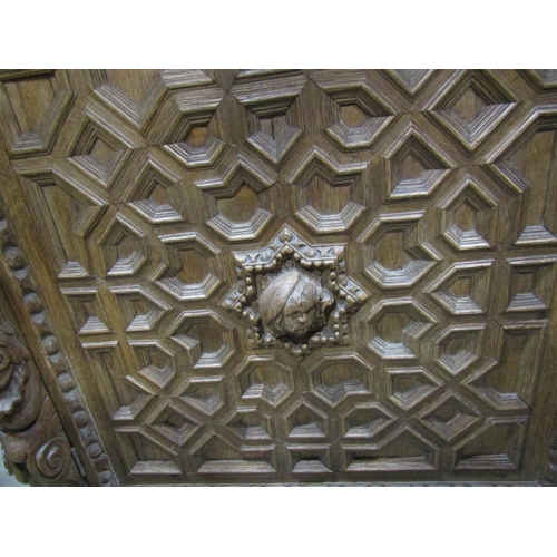 2246 - A substantial Elizabethan style oak side cupboard enclosed by a pair of panelled doors with geometri... 