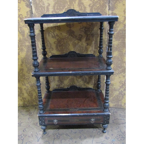 2384 - A Victorian three tier watnot with amboyna wood panels within an ebonised framework enclosing a lowe... 