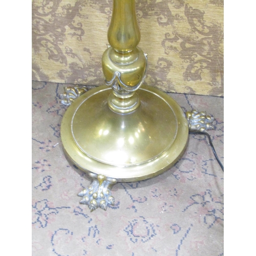 2388 - An Edwardian brass telescopic lamp standard, the circular base with lions paw feet