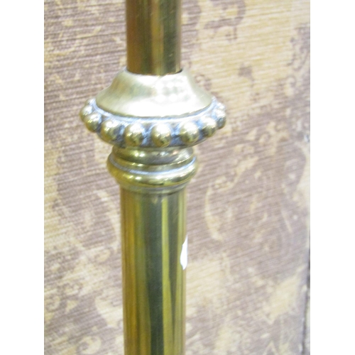 2388 - An Edwardian brass telescopic lamp standard, the circular base with lions paw feet