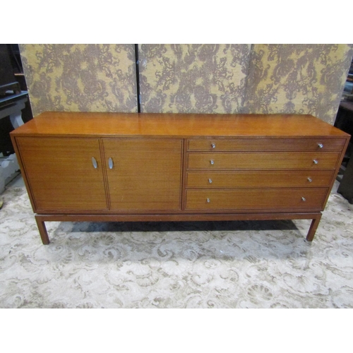 2257 - A mid century teak sideboard enclosed by two panelled doors and four graduated drawers on square cut... 