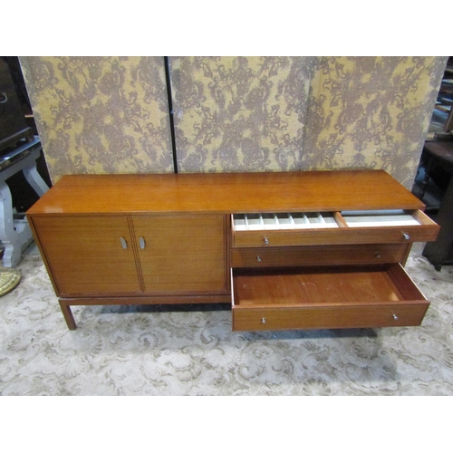 2257 - A mid century teak sideboard enclosed by two panelled doors and four graduated drawers on square cut... 