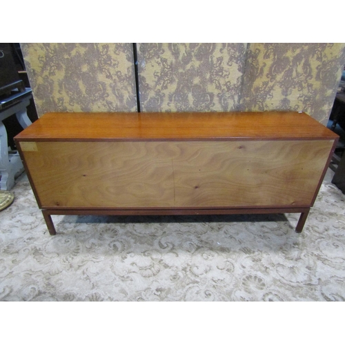 2257 - A mid century teak sideboard enclosed by two panelled doors and four graduated drawers on square cut... 