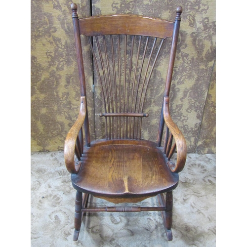 2438 - A 19th century ash stick back rocking chair with saddle shaped seat