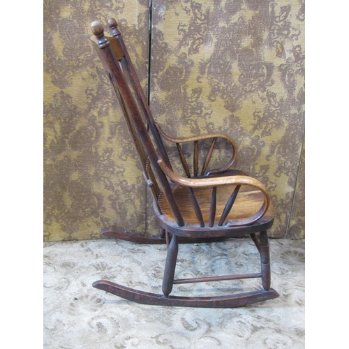 2438 - A 19th century ash stick back rocking chair with saddle shaped seat