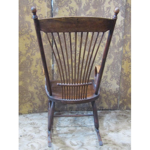 2438 - A 19th century ash stick back rocking chair with saddle shaped seat